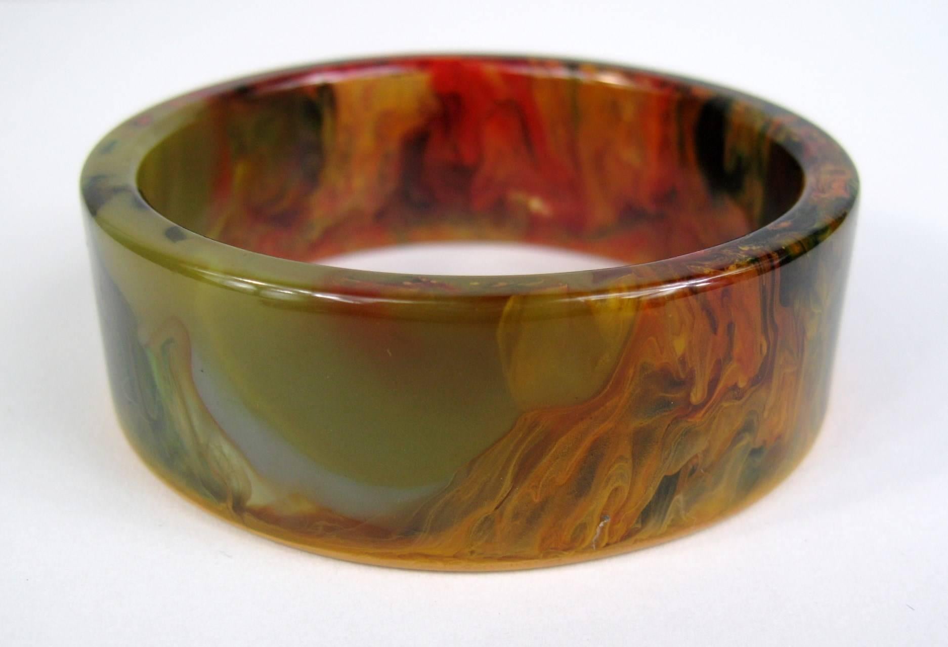 Stunning End of day Bakelite marbled with green, red, yellow and orange. Measuring 1 inch wide with a inner diameter of 64mm. This will fit a 6.5 to 7 inch wrist nicely. This is out of a massive collection of Jewelry from one collector. Be sure to