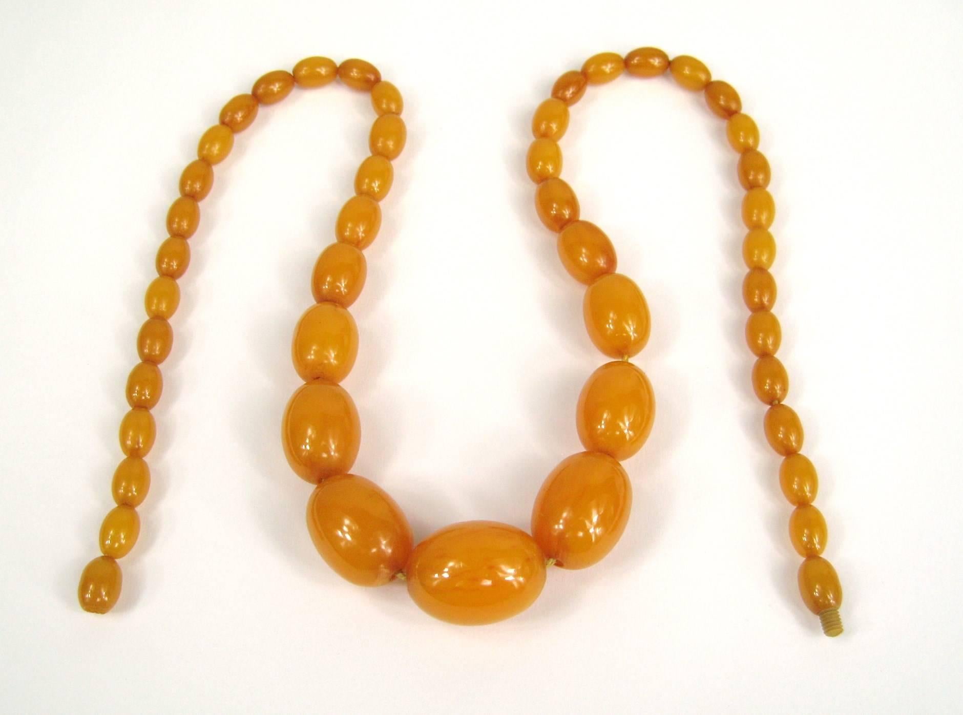 Vintage 1940s butter scotch Bakélite / Catalin collier. 47 perles de Bakélite allant de 19mm x 25mm jusqu'à 7.25mm x 10.5mm Total 25 pouces bout à bout. Le fermoir est d'origine avec une vis en os sculpté. Trueing By, pas une nouvelle reproduction. 