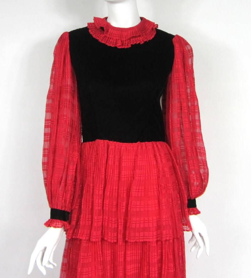 Superbe robe Givenchy rouge et noire. La jupe est composée de trois niveaux. Col volanté avec boutons-pression dans le dos. Dos zippé avec boutons-pression. Manches à boutons. Mesures Jusqu'à 34