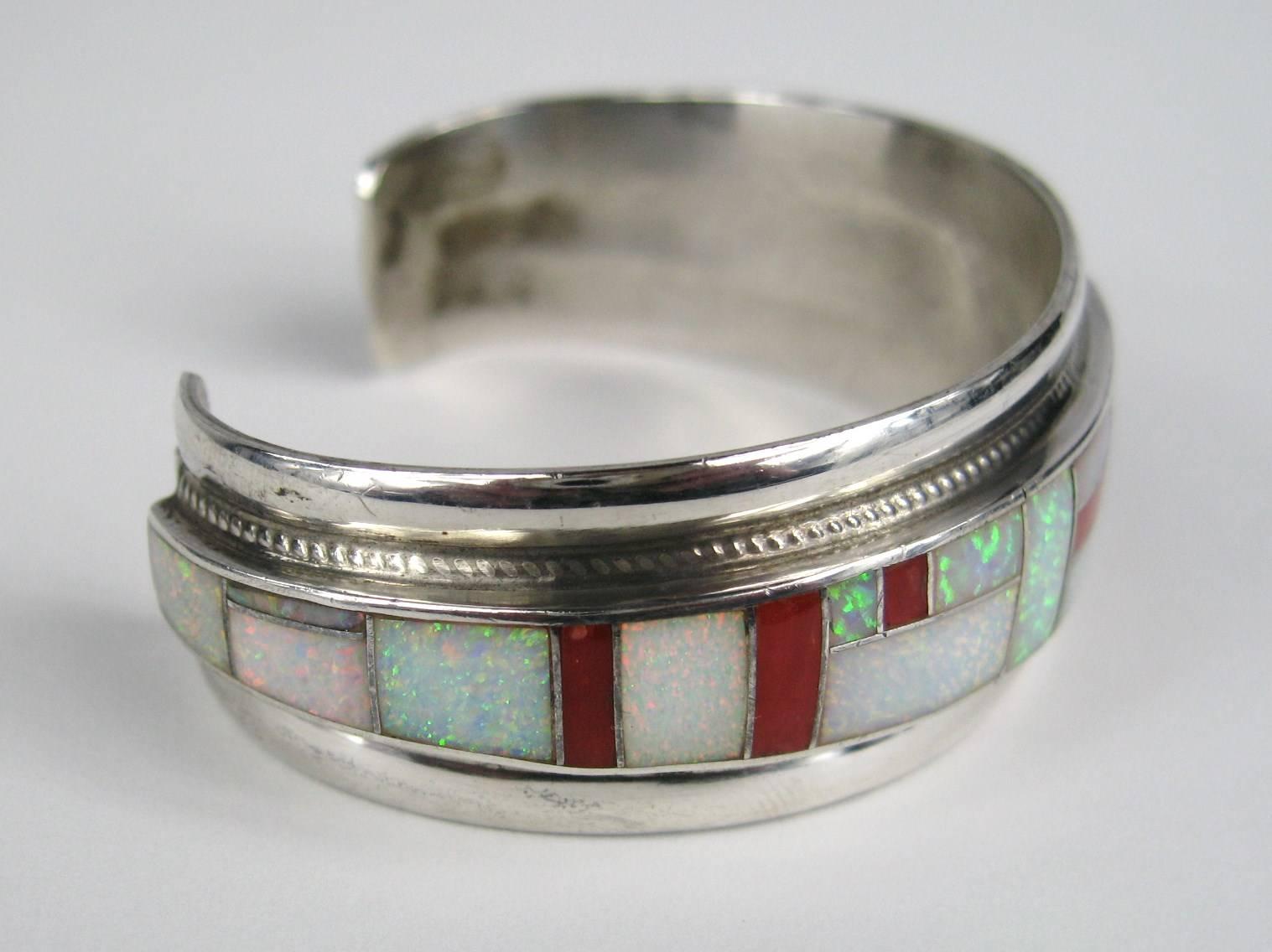 Stunning Opal and Coral inlaid Bracelet. Braided motif runs along both sides of the inlaid stones. Measures .88 in wide 1.40 in wide opening Will fit a 7.5- 8 in wrist. This is out of a massive collection of Hopi, Zuni, Navajo, Southwestern,