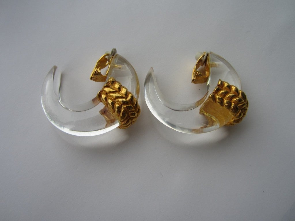 Vintage 1980's Dominique Aurientis Huge Hoops. These are Outstanding! Gold tone wide detailing on a clear Lucite Half Hoop Earring. Hallmarked on the inside of clip of the earring. 49.67 mm top to bottom or 1.95 in  x 49.20 mm or 1.93 in
Dominique