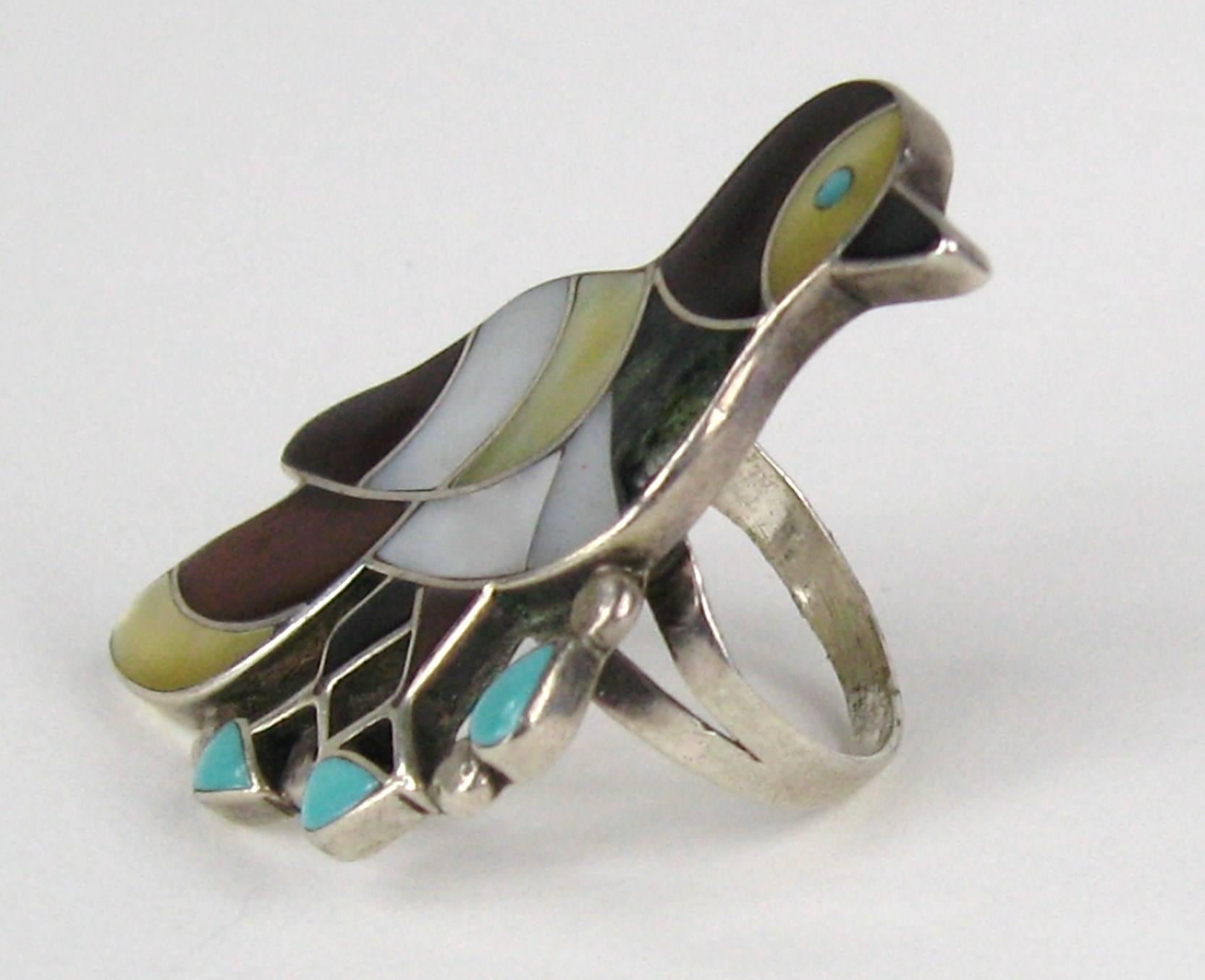 Stunning Inlay work on this piece made by silversmiths PORFILIO & ANN SHEYKA. More of their pieces are up for sale on our storefront. Ring measures 
1.53 top to bottom x 1.00 inches. Ring is a Size 7. This is out of a massive collection of