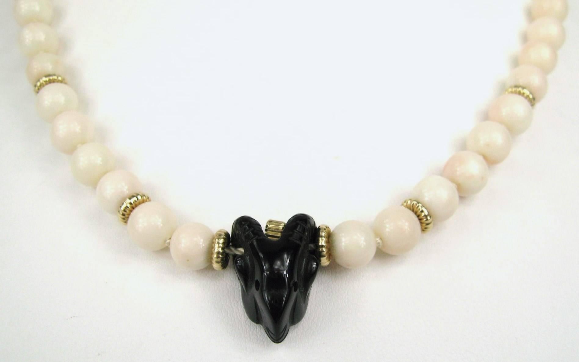 Stunning Coral beaded 14K gold necklace with Onyx Ram head. Ram head center with Gold rondelles bead scattered in between the coral beads, Beads measures .32 in. or 8.15mm and the ram is .82 in.  x .46 in. The Necklace measures 19 inches end to end