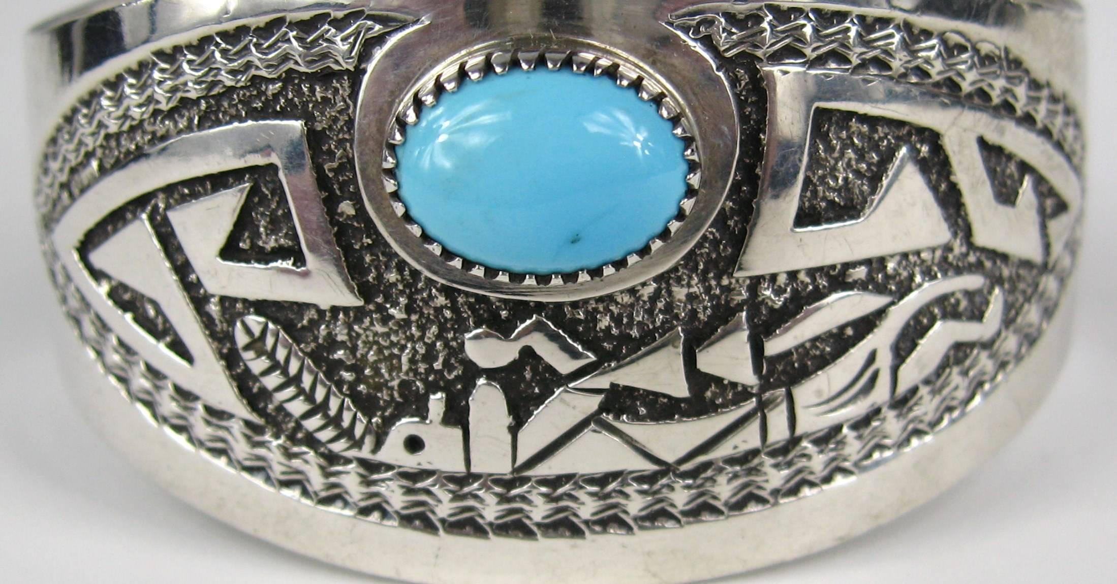 Stunning Navajo Sterling Silver Bracelet. Engraved Dancer. Has a Large Bezel Set Turquoise Stone. Hallmarked Gibb. Measuring 1.32 in. wide with a .96 in. opening. Will fit a 6.5 in. to 7 in. wrist and can be adjusted a bit smaller or larger. This is