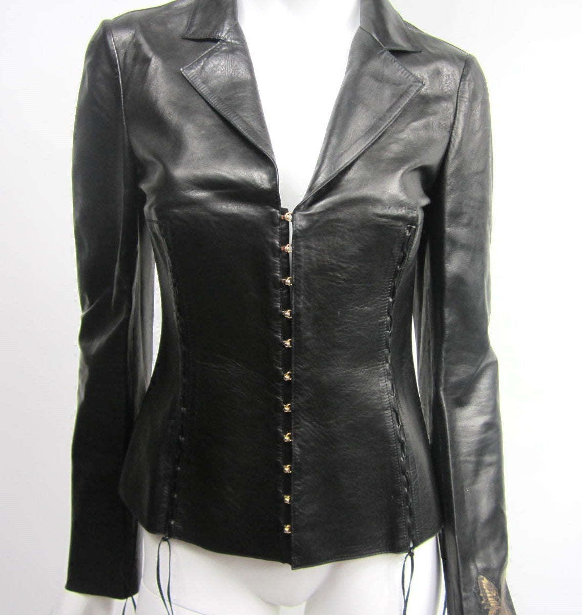Laced up detailing on this butter soft leather jacket. Butterfly detail on left arm. Closures are Gold tone detailed hardware. Jacket is a XS-S. Great Rough edges on this one. Lacing detailing on this jacket are fabulous! Measures up to 34 in. Bust