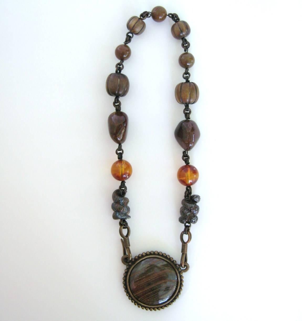 Amber and Wood Snake Disc Necklace. This dates from the 1980s. Purchased and never worn. We have a lot of never worn Dweck on our storefront. Wood Disc Dweck Necklace with a  Interchangeable Pendant. Details-- Amber Beads,  Carved wood Beads and