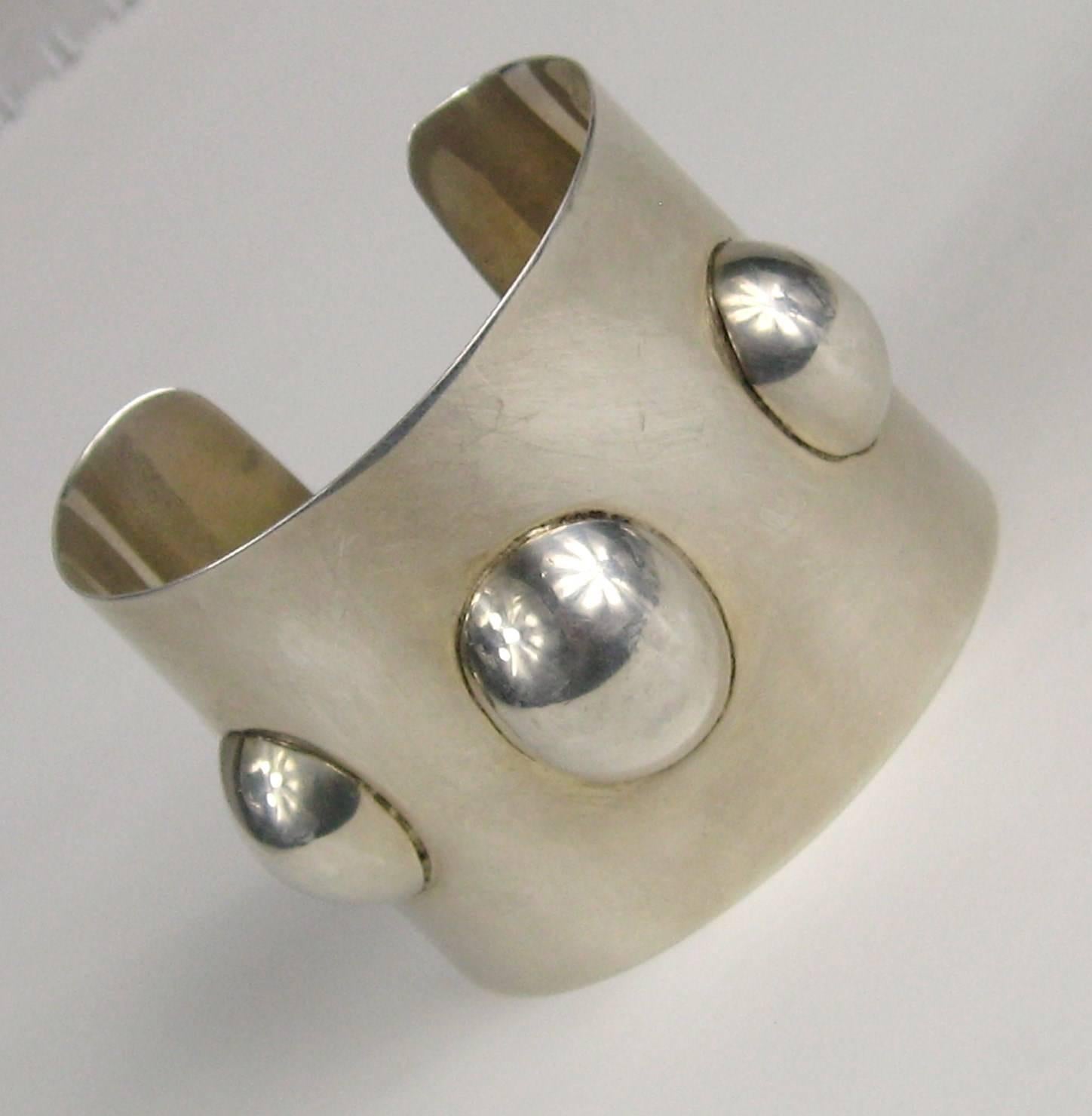 Stunning Sterling Silver Mexican Cuff  with a Sleek design with surrounding ovals. Measuring 2.06 inches wide or 52.49mm it will fit a 6.5 up to an 8 as sterling is pliable. The Bracelet is hallmarked insidefrom a shop in Mexico called Perlita. This