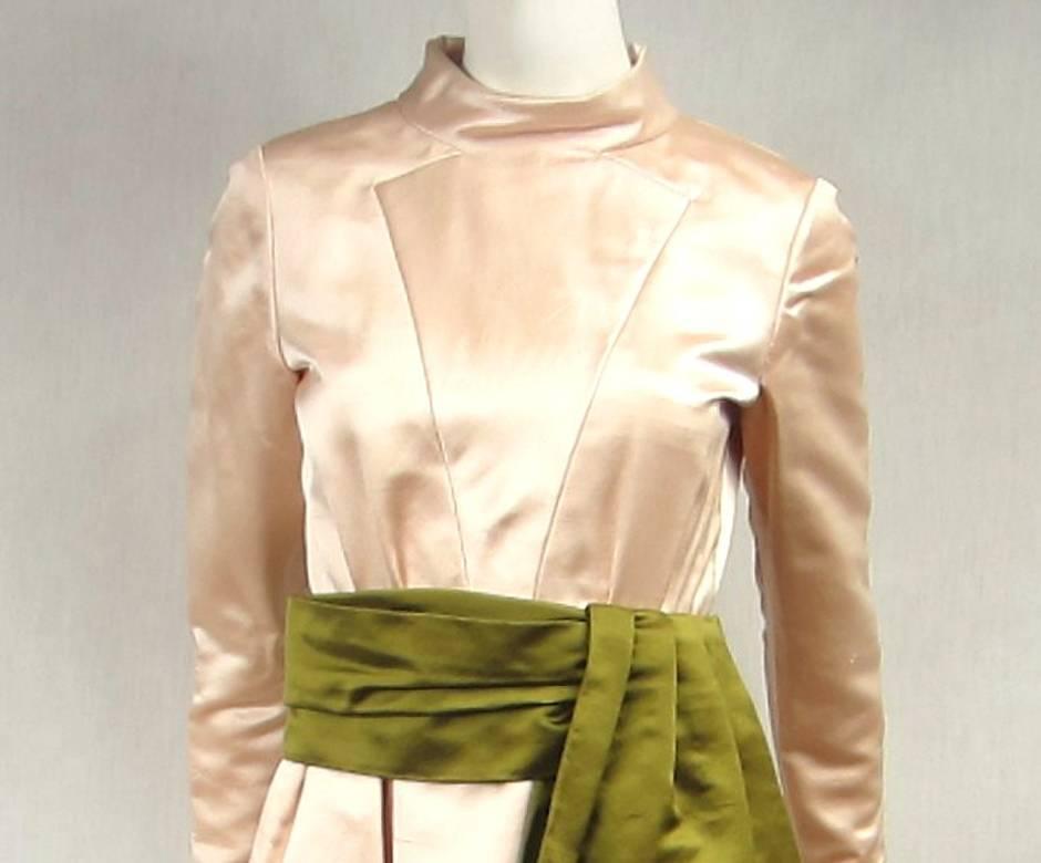 Pale Pink Teal Traina Dress. A wonderful pale pink heavy Dupioni silk with a Large Wide green silk obi style Double Sash. Stand up collar. fabric covered buttons on the sleeves. Zippers up the back. Full skirt with a large pleated front. Pockets,