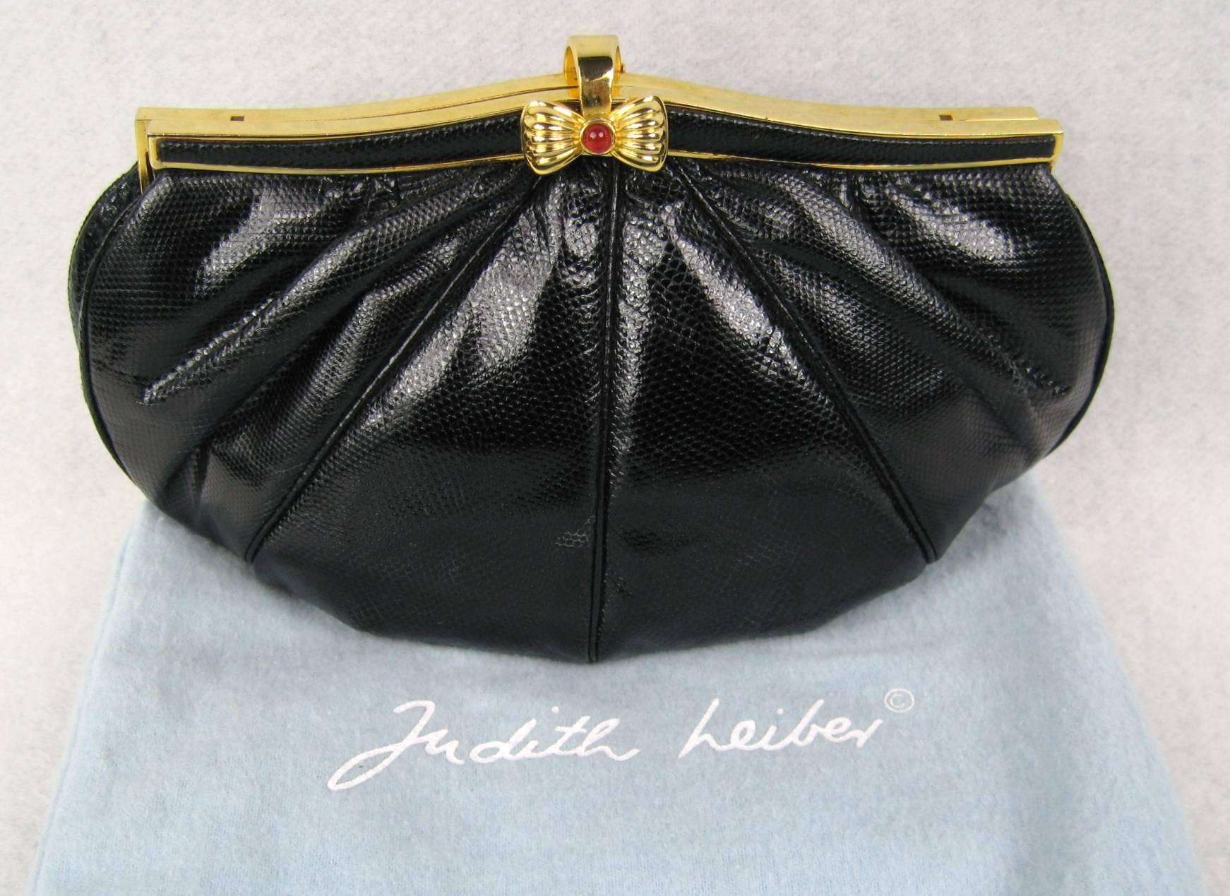 Black Snake Skin Judith Leiber Clutch Red Cabochon Bow Closure. Measures 9 inches wide x 5 inches  top to bottom. Chain 20 inches long. Be sure to check our store front for more fabulous pieces from this collection. We have been selling this