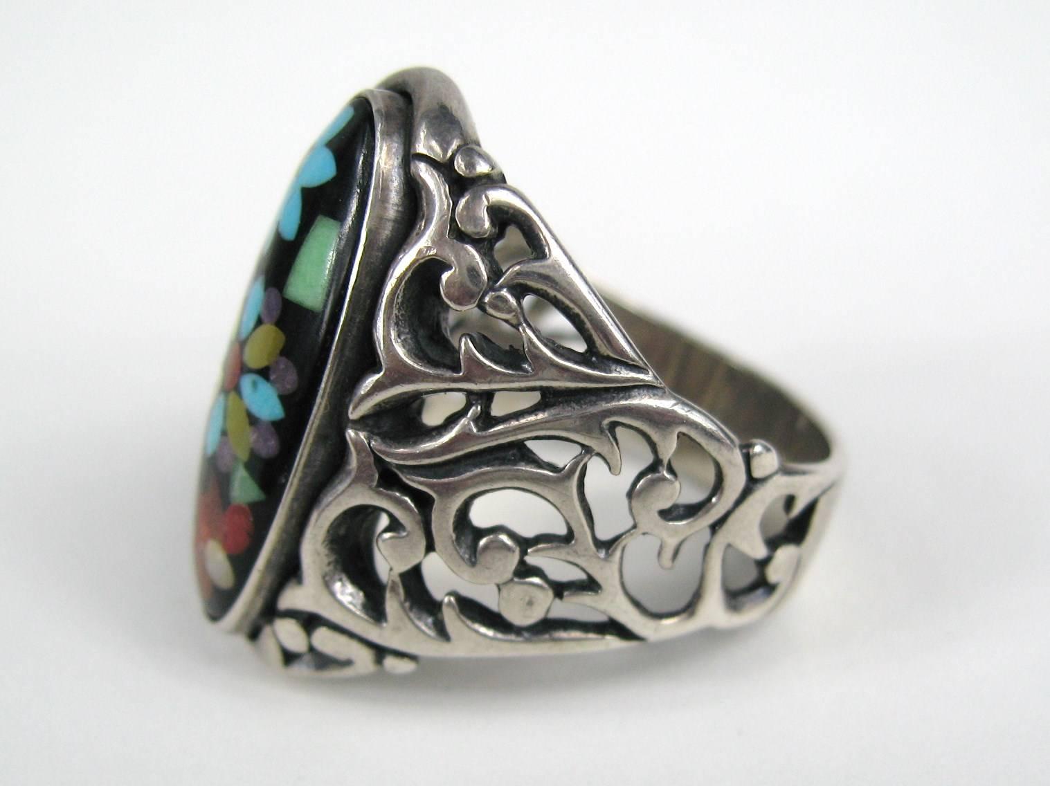 Large Open cut work sterling silver ring. Onyx with Turquoise, coral and amethyst. Top of the ring 1.07 in. top to bottom x .50 in. wide Ring measures 10.5. This is out of our massive collection of Hopi, Zuni, Navajo, Southwestern, sterling silver,