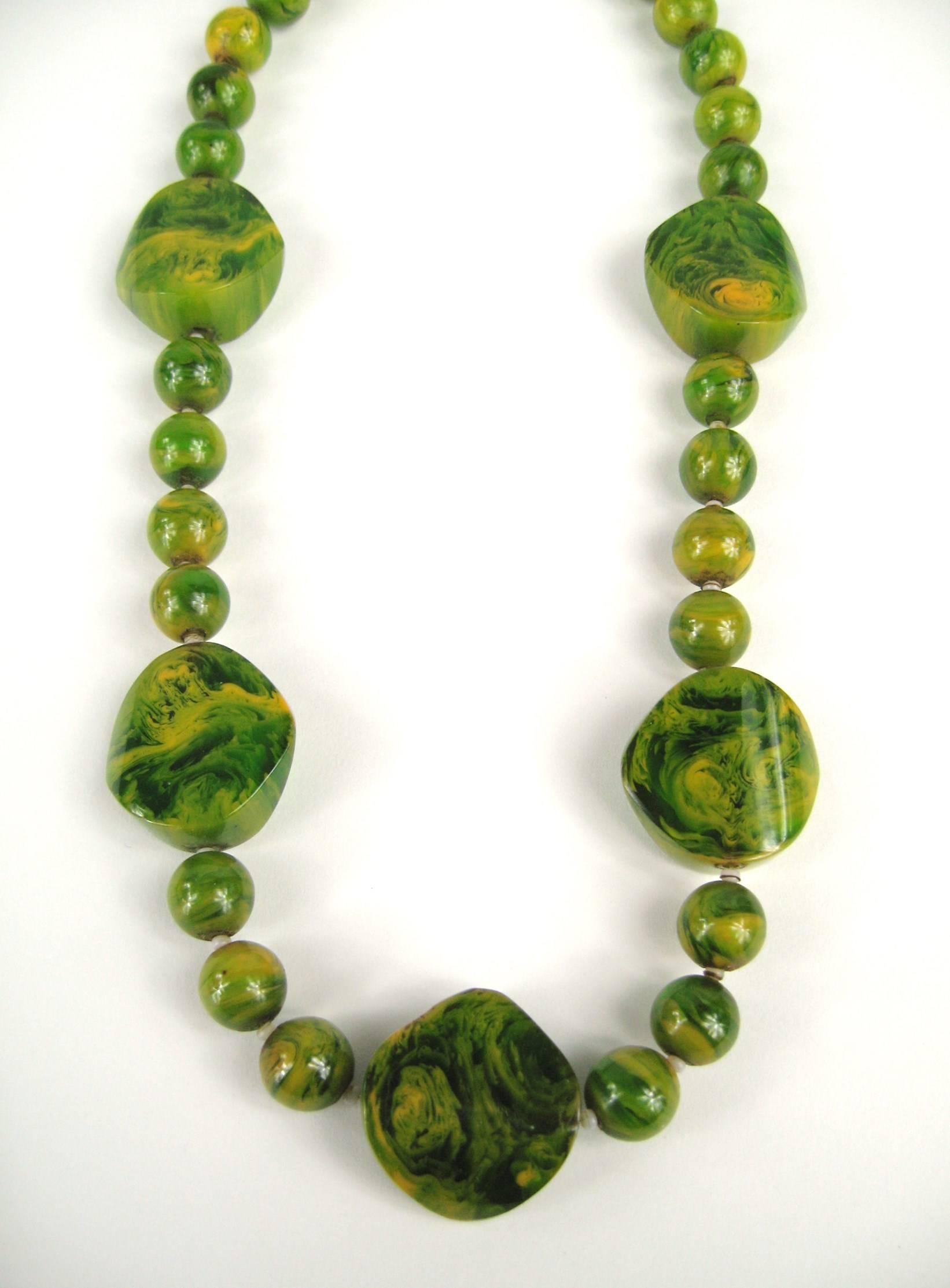 Vintage Green Bakelite / Catalin Necklace.Graduating round beads along with larger accent Bakelite bead. Beads 10.86 mm down to 10.36mm, Large disc beads are 24.78 mm x 24.66mm. Measuring 20 inches end to end with a Barrel screw closure. About 3