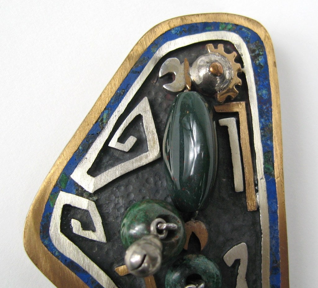 Vintage Sterling Silver Mexican Bird Pendant / Pin with Inlaid Lapis with mix gems of Bloodstone and Malachite. Brass / Sterling Mix on the piece itself. Doubles as a Brooch and Pendant Measuring 3.13 top to bottom x 1.94 wide. This is out of a