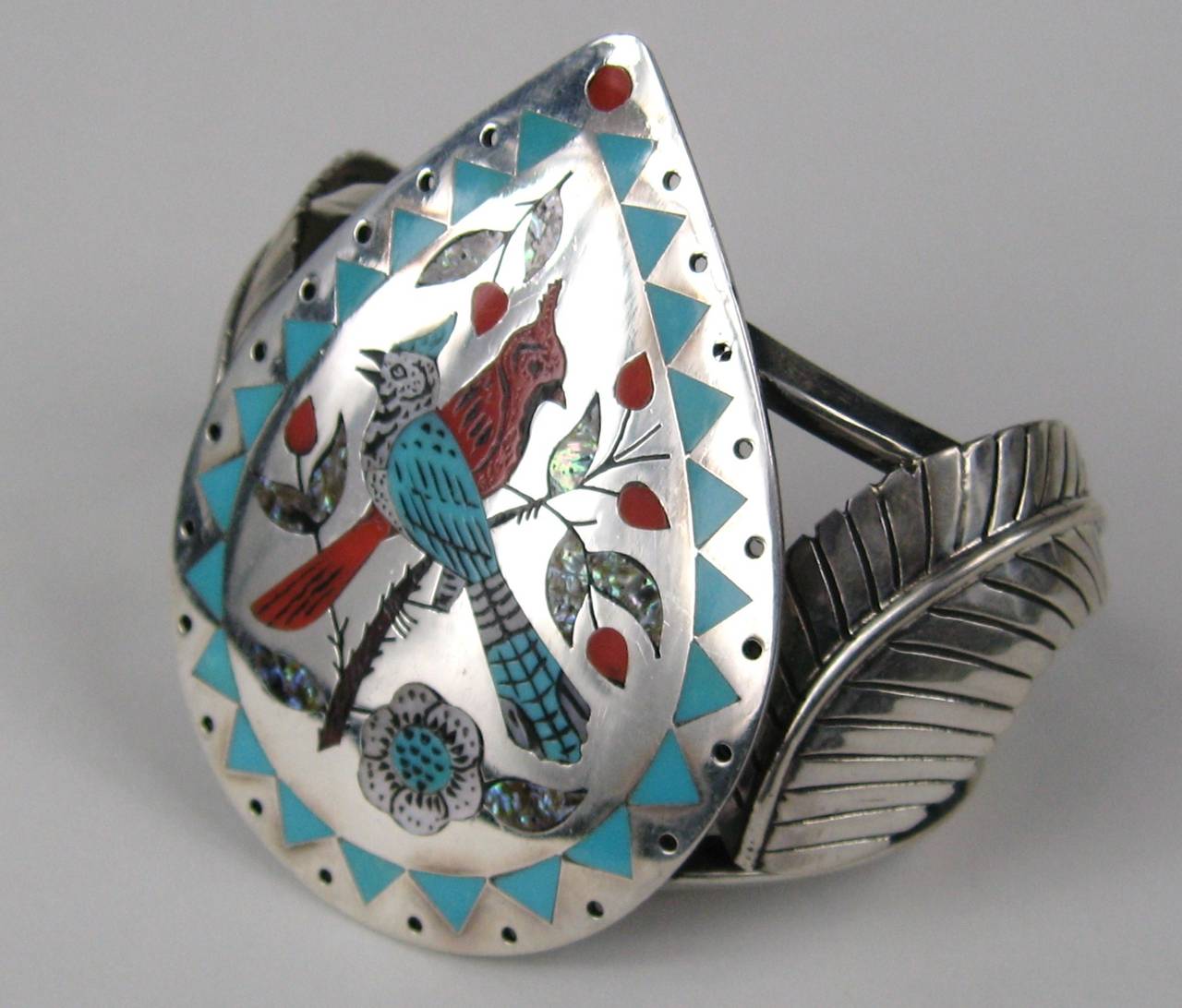 Stunning large inlaid Zuni Cardinal Bracelet by Raymond Boyd. Circa early 1970s . Measuring 2.44  x 1.82 on the face of the bracelet with a 1.10 opening 
Has a bit of give. Will fit a 6.25 up to a 7.25 depending on how you like your fit. Teardrop