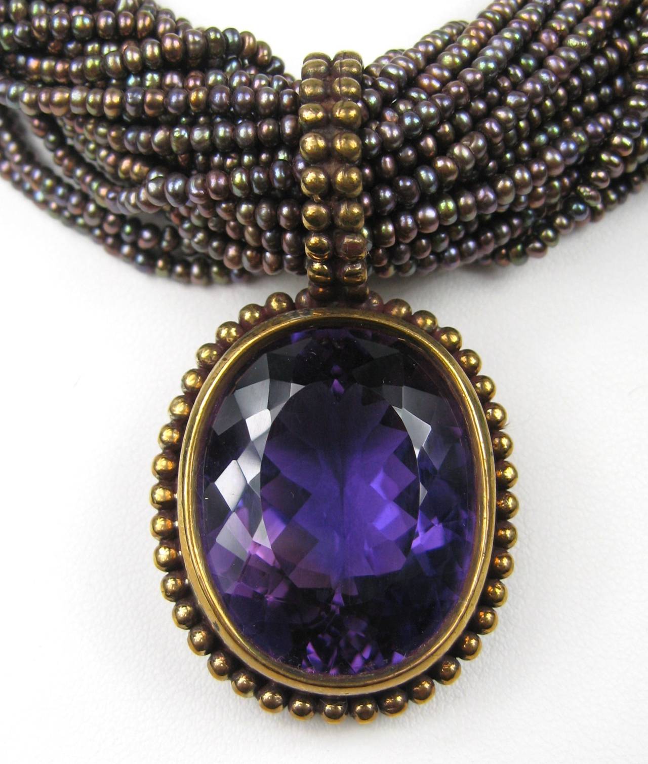 Dweck Bronze Amethyst Drop Necklace, simply stunning! Necklace is made up of tiny amethyst beads 32 strands. Drop at the bottom is a faceted Amethyst. measures 17 inches  end to end. Price tag sill attached. This is out of a massive collection of