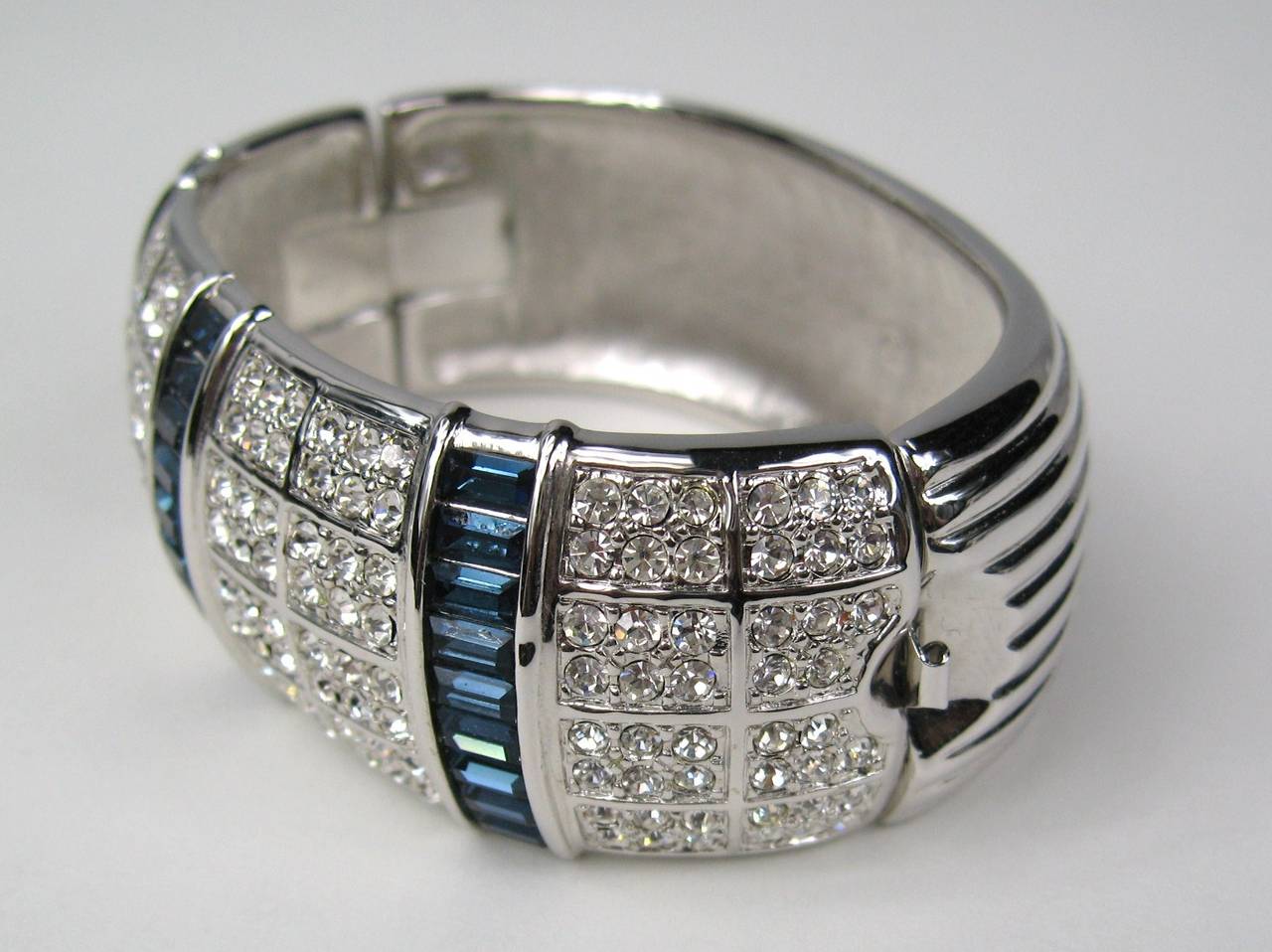 Stunning in person. Wide oval bangle with both blue and clear Swarovski Crystals channel set on the entire top of the bracelet with a slide in clasp. Measures 1 inch wide. will fit a 6 to 7 inch wrist. This is out of a massive collection of Hopi,