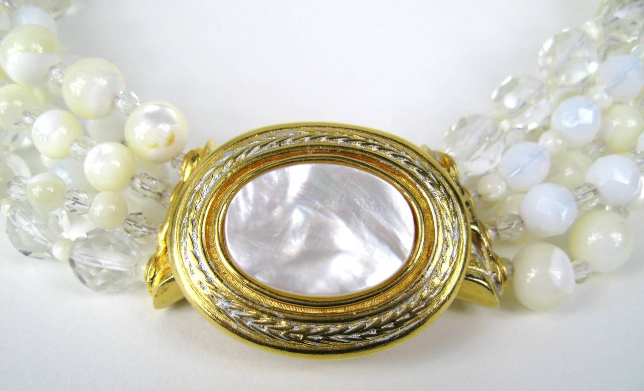 Collier Barrera avec des perles en verre blanc mat et transparent. Grand fermoir en nacre. Mesure 19 pouces d'un bout à l'autre. Les perles vont de 9 mm à 5 mm. Le fermoir mesure 1,63 x 1,30. Ce bijou fait partie d'une énorme collection de bijoux