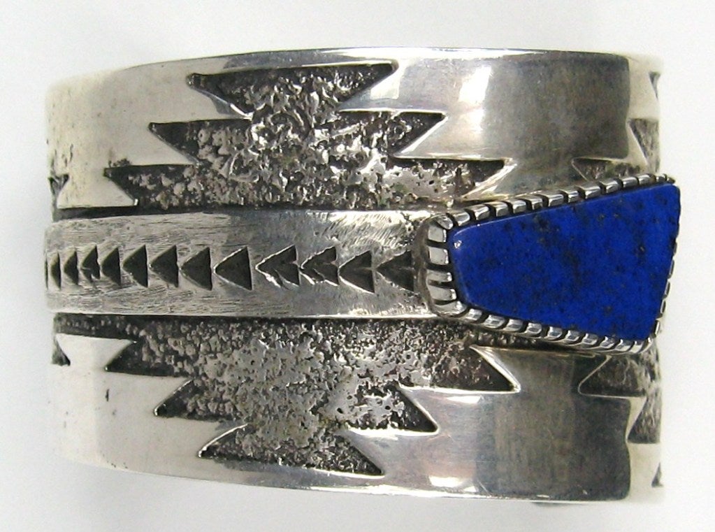 Highly detailed Sterling silver Cuff Bracelet signed T Jackson- Hallmarked 1987. Measures 1.76  at one end than tapers down to 1.36  at the other end.  Bezel set Lapis stone. Will fit a 6-7-1/4 can be made a bit smaller of larger due to sterling