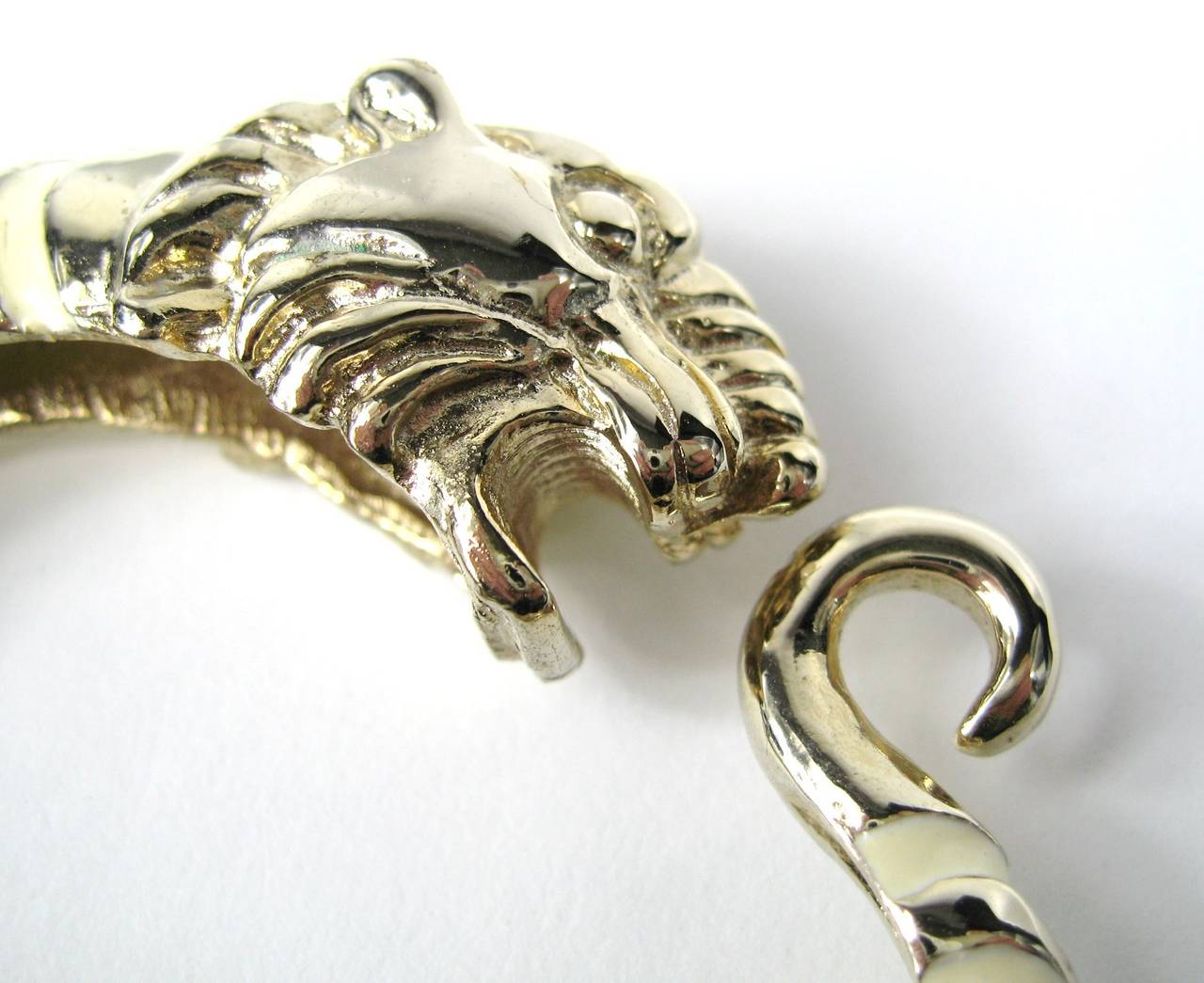 Une grande tête de lion sur ce bracelet Donald Stannard Gold Gilt à l'action printanière, mélangé à de l'émail beige. Le bracelet s'adapte à une taille de 6 à 7 pouces  poignet, en fonction de la taille du bracelet - 2,50 in  intérieur x 1,50 in. 