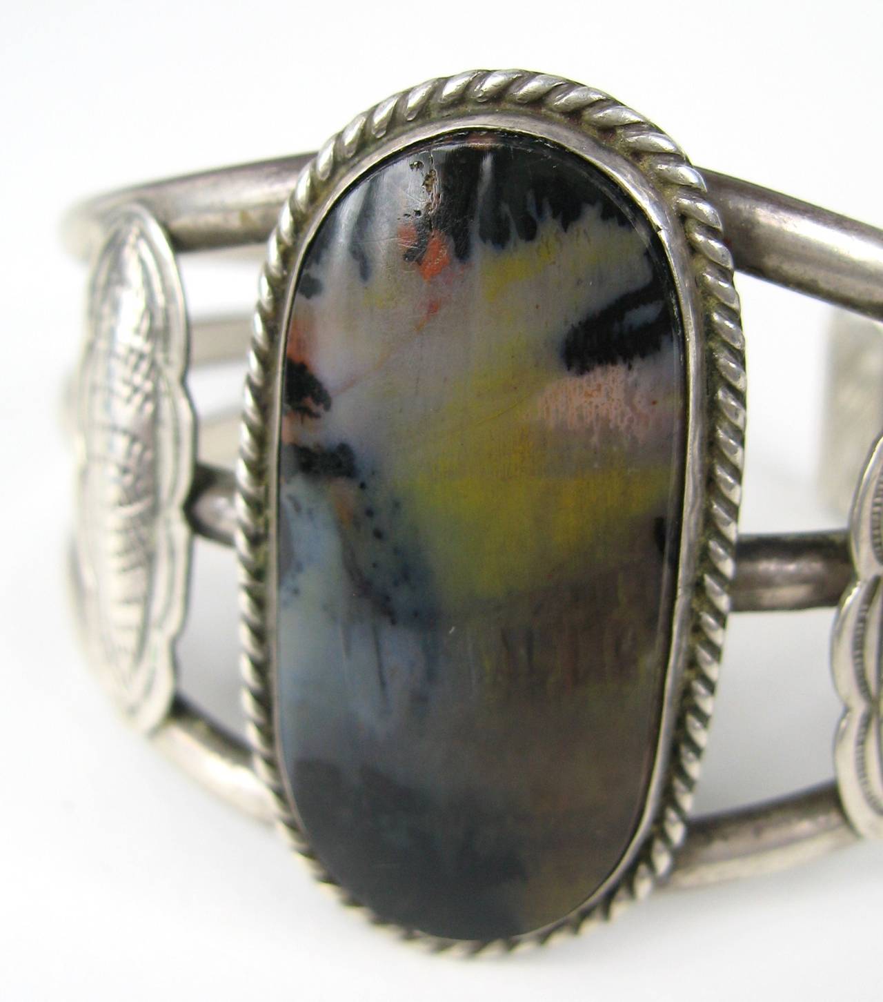 This is a stunning Scenic Petrified Wood Cuff with 3 Wires. Oval Center measuring 1.77 inches x .95 inches - Opening 1.20 inches. Will fit a 6-7 inch wrist. It has give to it. This is out of a massive collection of Hopi, Zuni, Navajo, Southwestern,