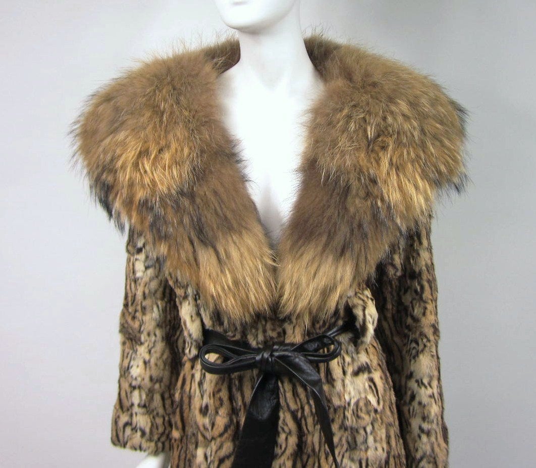 Huge Fur collar as well as the Scalloped Trim on the bottom. Belt, belt loops are made into the coat. Hook closures down the front. Will fit a size 8-10 Measures Bust up 36in. Waist up 30in. Hips open- Length 46in. Sleeve 23in.  Please be sure to