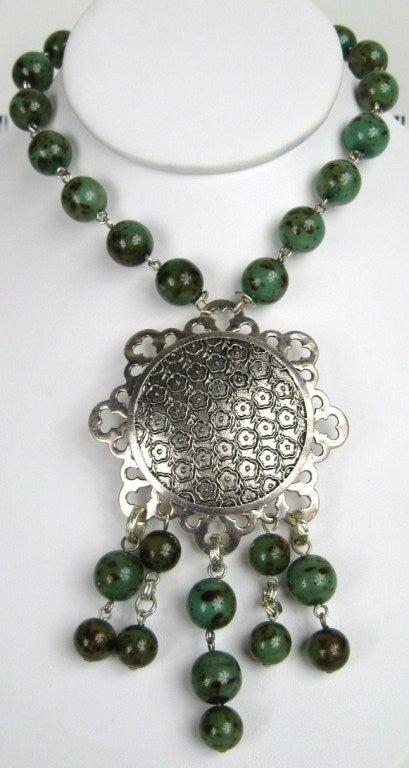 Eine weitere Kreation des Pariser Kunsthandwerkers Dominique Aurientis. Silberne Scheibe mit einer sehr langen Perlenkette. Kippbarer Verschluss. Lässt sich bis auf 47 Zoll herunterlassen und kann doppelt um den Hals getragen werden. Dominique