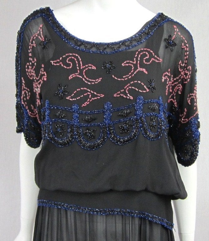 Stunning 1920's beaded drop waist dress. Flapper era. Snaps closure up the side and along the sleeve. Scalloped Sleeves. Lined with a silk slip. This is truly a stunning wearable flapper dress, tiny bit of bead loss Chest up to 42 - Waist up to 36 -