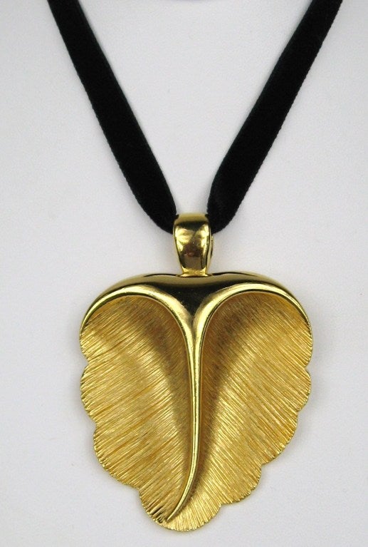 Large Leaf on a black velvet ribbon. The ribbon is 32 inches long and can be tied so you can wear different lengths. Brushed gold-tone inside leaf with a high polished gold that gives dimension to this piece. This is out of a massive collection of