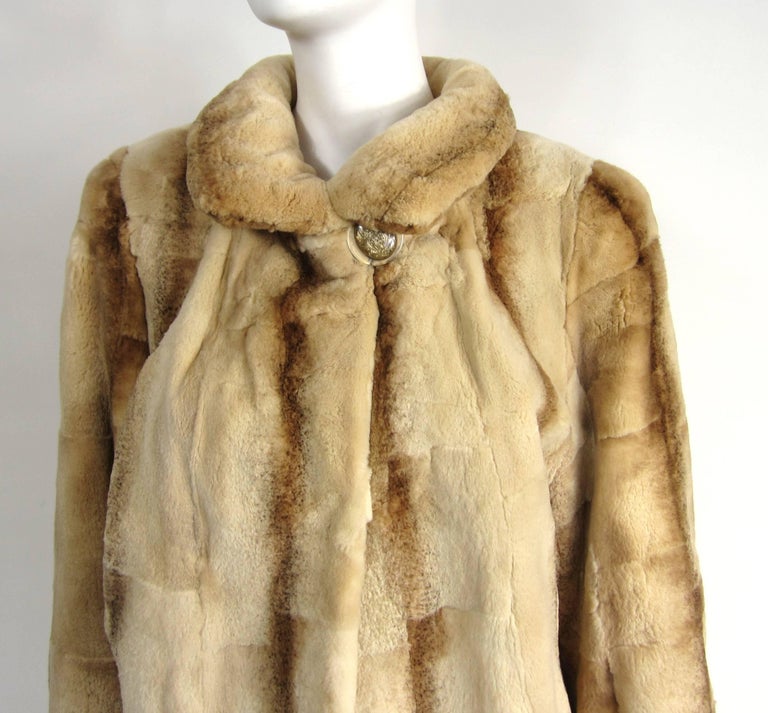 This is a stunning vintage sheared Mink fur coat that looks like shearing. Large Button at the neck, with 3 fold over closures down the front. Slit side pockets. Monogrammed on the lining. The lining is a spectacular color, see photo's. This is in