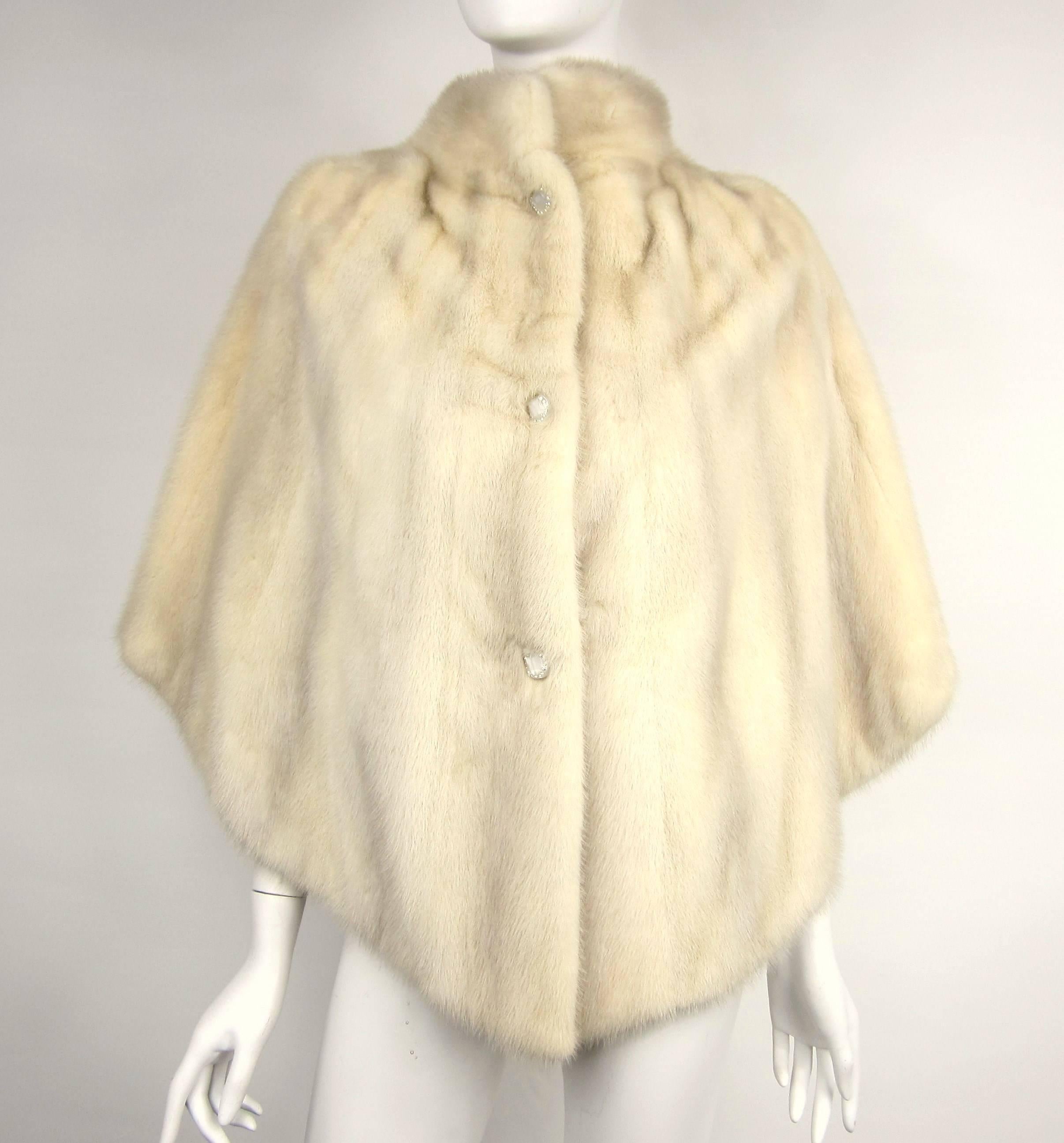 Here is a Wonderful reversible Pearl White Mink Caplet. Mink is soft and supple. Has a 3 Buttons closure, Pockets on the opposite side. Monogrammed inside. Measuring 28 in long, and will fit a small - Med. We have many more minks, foxes, and finches