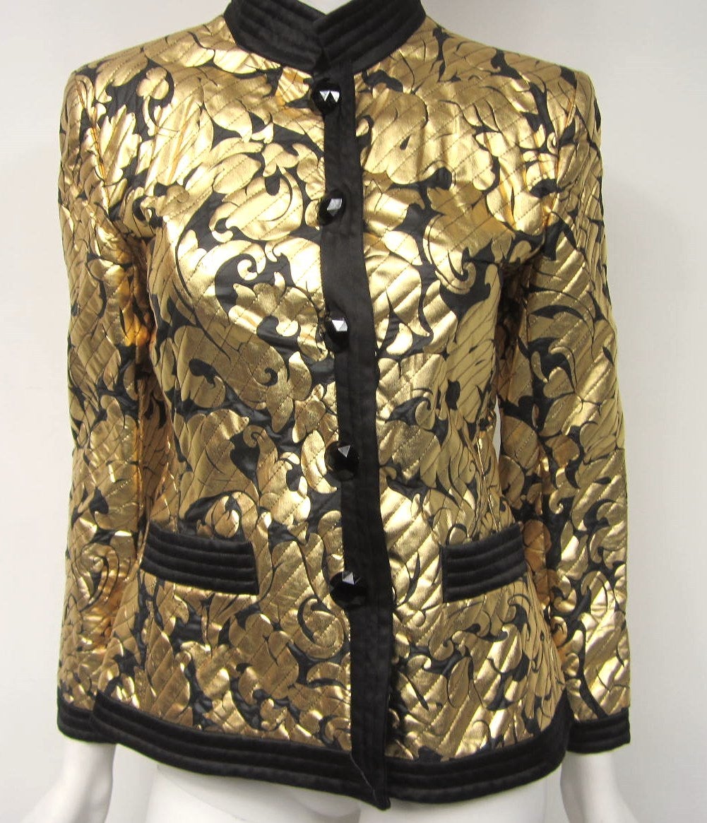 Stunning Saint Laurent Black and Gold Jacket with Quilted Mandarin Collar, Cuff, pockets and bottom Trim. Black Glass buttons. Bold gold pattern stenciled. Size 38 Measuring - Chest up to 36- Waist 32- Bottom of jacket 38- Length from bottom of neck