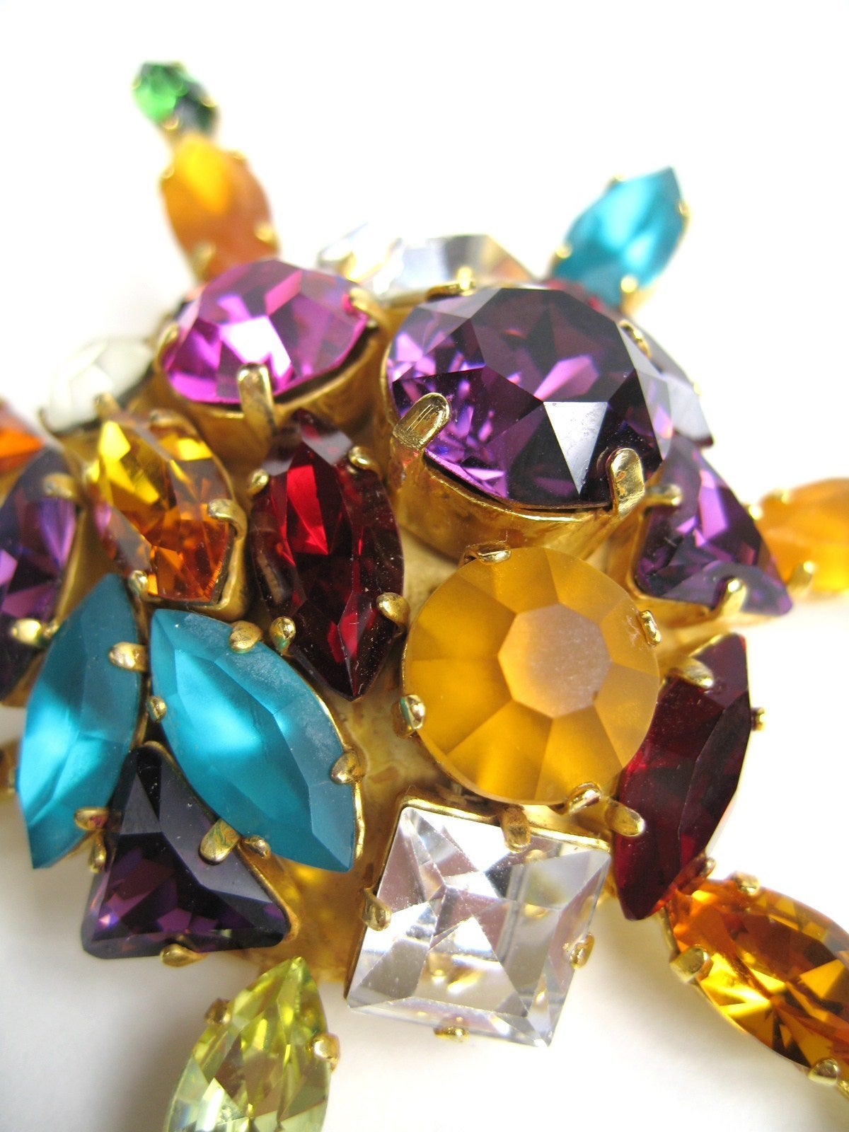 It an explosion of crystals from partisan artisan Dominique Aurientis. This pin is set in a gilt metal with crystals that have a host of colors, sizes and shapes. The earrings have marquise set crystals in various bold colors. Pin measures 3.75
