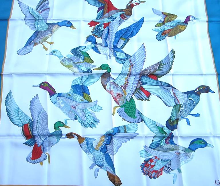 This is from a Vast Collection of Gucci Scarves that have never been worn. Featuring Flying Birds. Vibrant Blues, greens, on a white background. Made in Italy. Hand Rolled Silk. This is out of a massive collection of Contemporary designer clothing
