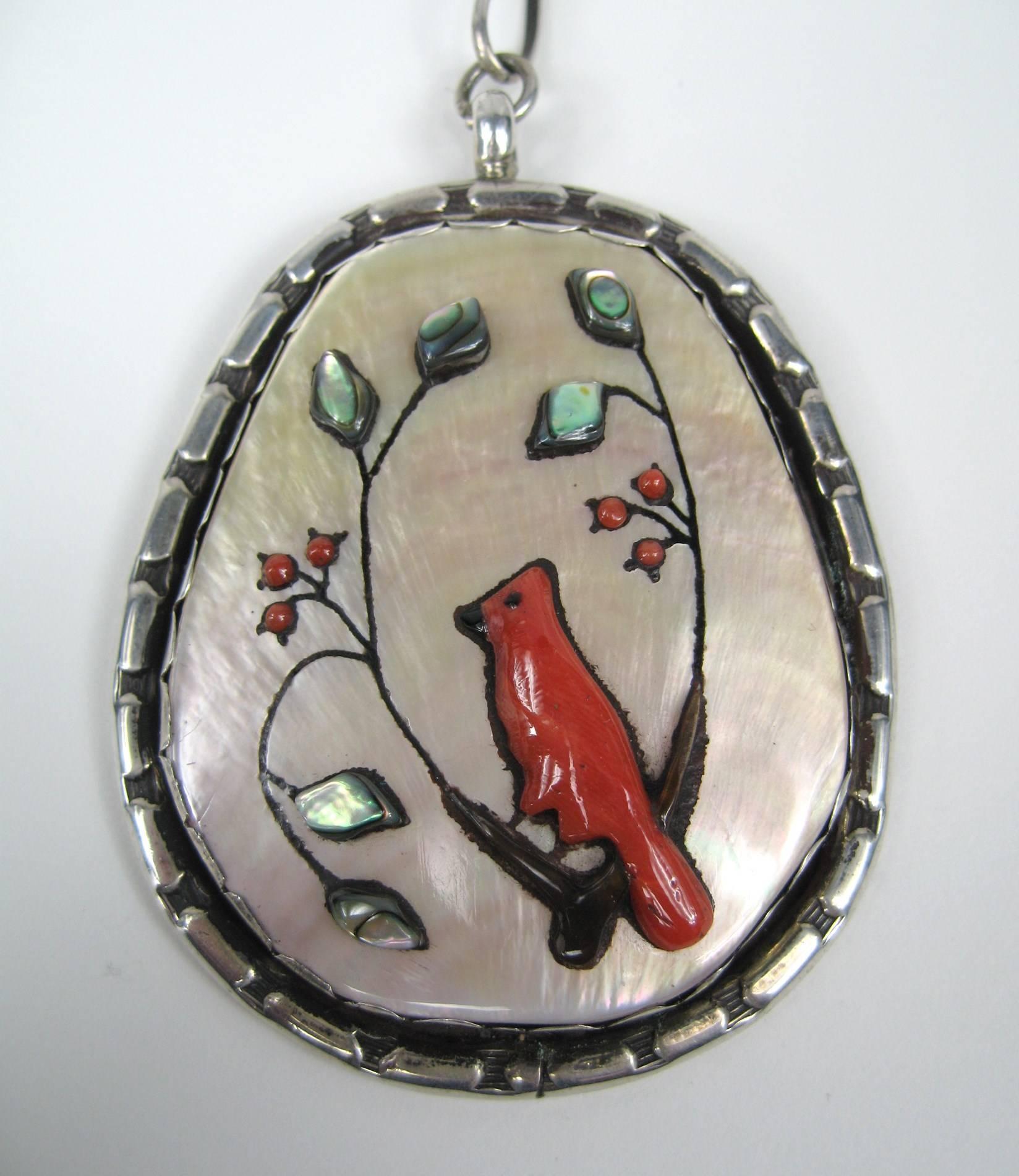 Stunning Pendant depicting a Cardinal Large in scale made up of Shell with inlaid Coral and Abalone. Cardinal sitting on a Tree Branch, Hallmarked on the back side. Large link necklace attached Measures 2.56 in x 2.19 in. The Links are .57 in x .23
