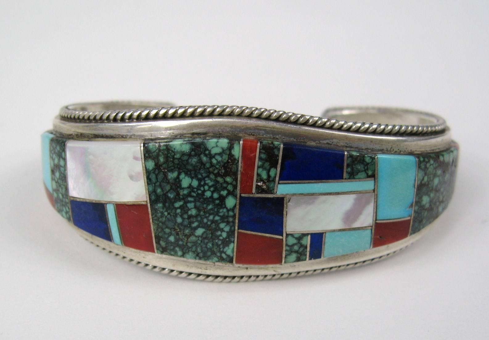 Bracelet is made up of turquoise, spiny oyster, lapis lazuli, Coral and mother-of-pearl. Exceptional quality inlay workmanship. Measuring 1.04 in wide 1.11 in opening. Will fit a 6.5- 7.5 in wrist has a bit of give.  This is out of a massive