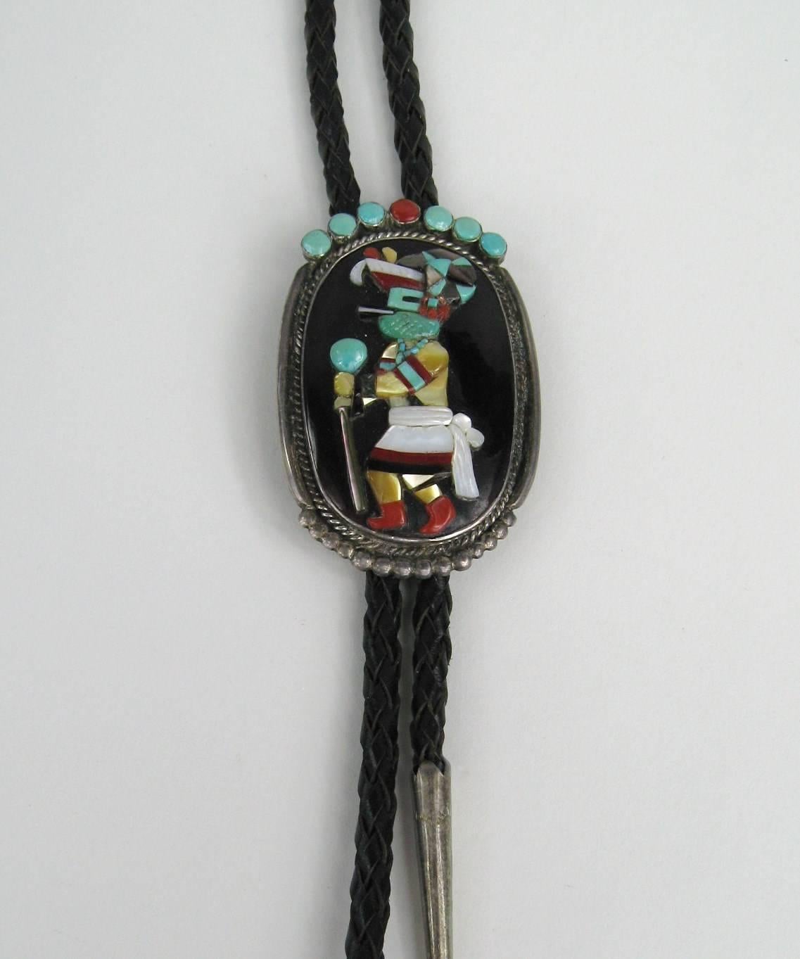 Stunning Workmanship on this Bennett Bolo with a Variety of stones such as Turquoise Coral Mother of pearl Abalone.  measures 2.50 in Top to bottom x 1.65 in. The Leather braid measuring 38 inches long. This is out of a massive collection of Hopi,