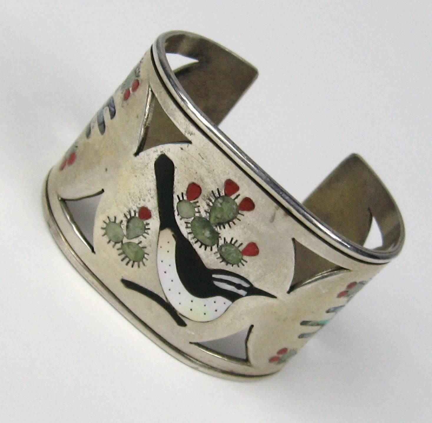 Lovely inlaid Zuni cuff depicting a Bird with Cactus Nice wide cuff. Measuring 1.65 in wide Opening 1.05 in will fit a 6 to 7 wrist, does have some give to be made smaller or larger. This is out of a massive collection of Hopi, Zuni, Navajo,
