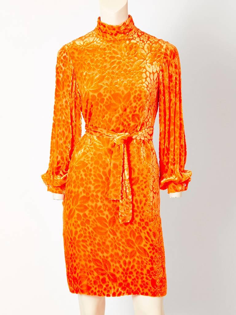 Rudi Gernreich, tangerine tone, cut velvet on chiffon, belted shift, having a mock "turtleneck" collar, and long full sleeves that end in a cuff. Middle back zipper closure. C. 1960's.

