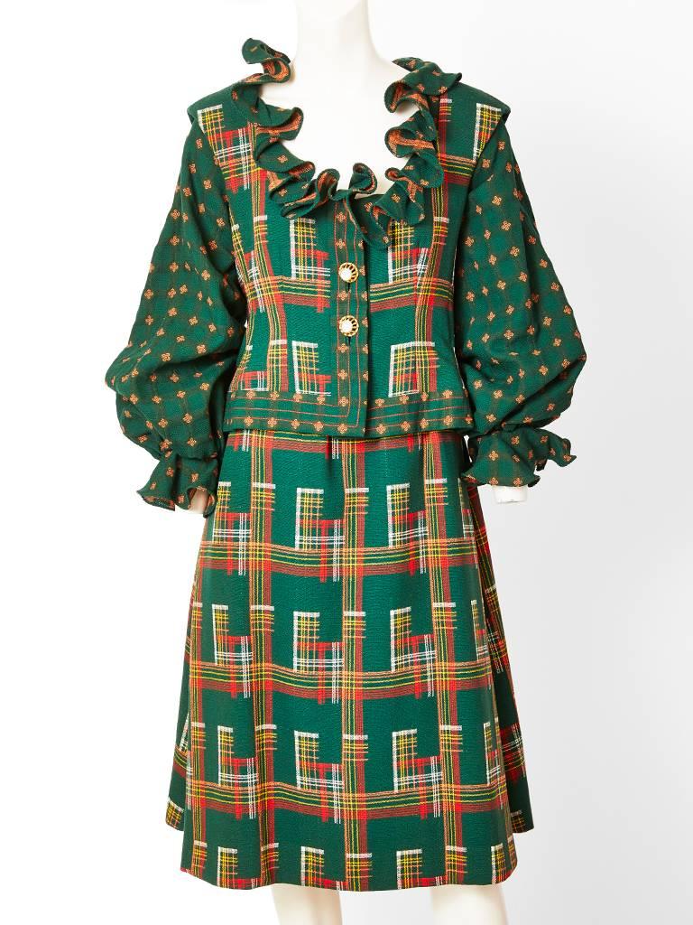 Ronald Amey, multi patterned, wool dress and sleeveless vest/ jacket. Dress bodice, has an open neckline trimmed in a soft ruffle, and balloon sleeves that are tight at the wrist having a ruffled cuff. The top is a rich forrest green foulard print.
