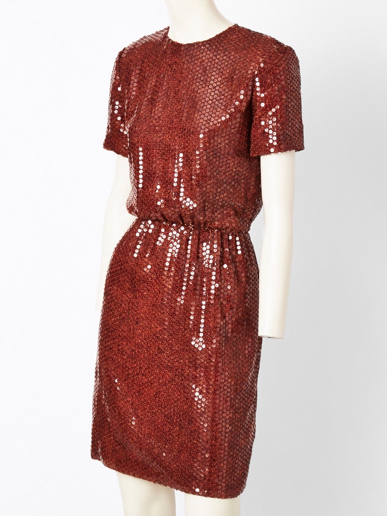 Bill Blass, tortoise shell, sequined, jeweled neck, short sleeve, cocktail dress.
Skirt is straight and top blousons at the waist.