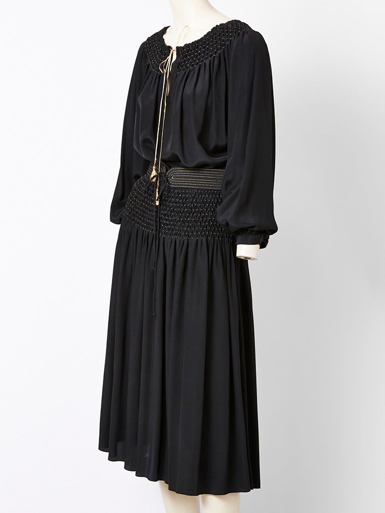 Black ,Silk , 2 piece , ensemble, inspired by YSL Russian collection.  Top is 
gypsy style, full sleeves,  with smocking at the neckline using gold thread. Tie is gold too. Belt has gold top stitching. Skirt is full, and smocked from the waist down