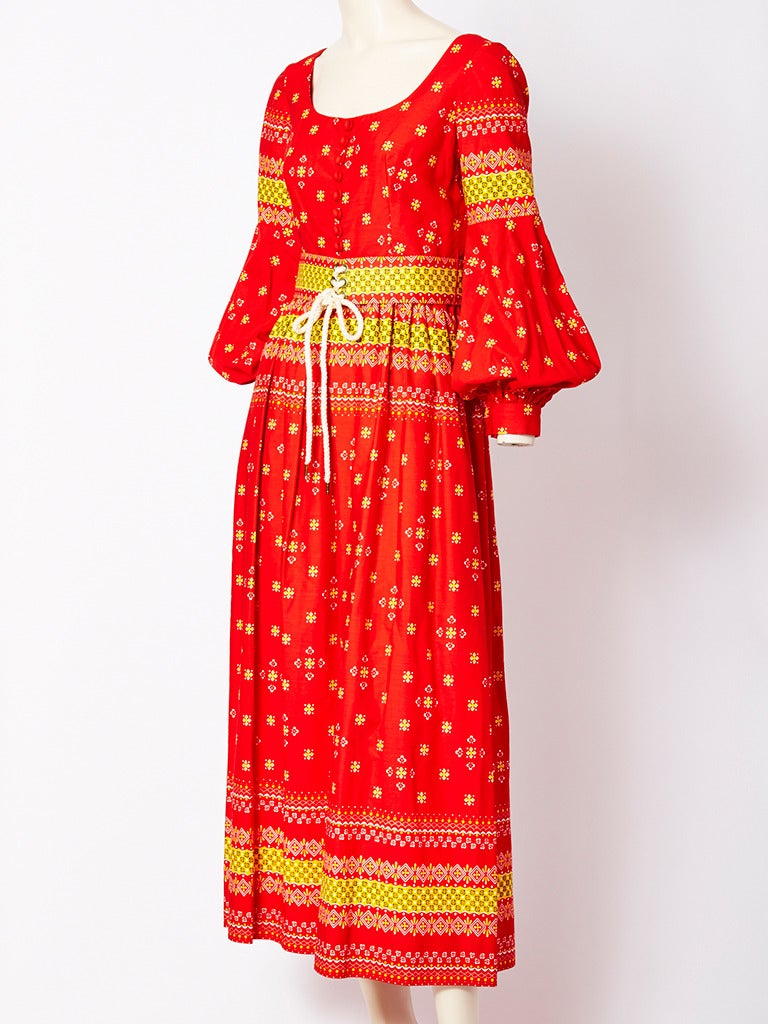 Oscar de la Renta, colorful, cotton, printed, peasant style,maxi dress, having a self belt that laces in the front, scoop neckline, full sleeves and button detail on the middle of the bodice. C. Late 60's.