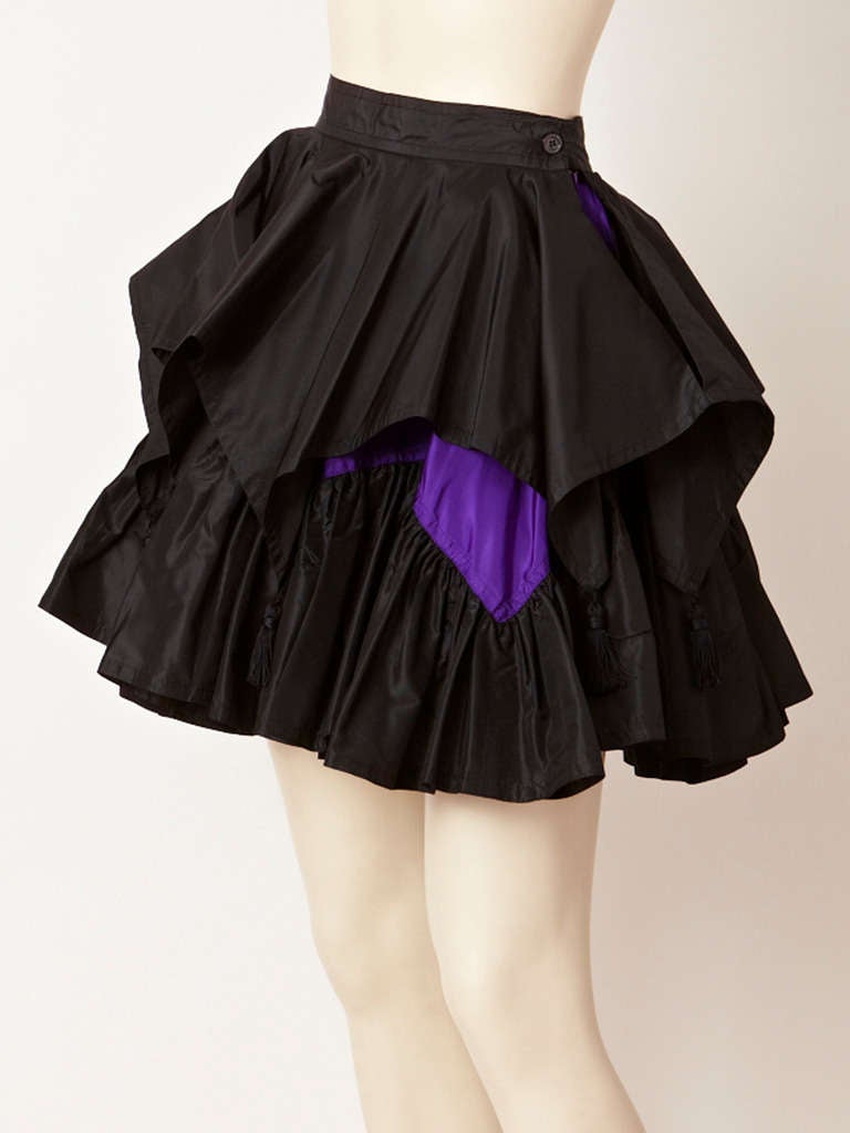 Angelo Tarlazzi, black and purple taffeta tierd skirt with tassels. Top tier is pointed with a purple under layer and tassels and the end of each point.
Second tier is gathered.