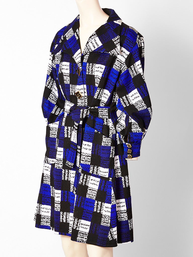 Christian LaCroix, graphic, geometric print, textured cotton, belted coat dress having a fitted bodice, full, paneled skit, inverted back pleat, and large pockets.
Embellished with large square enameled buttons...