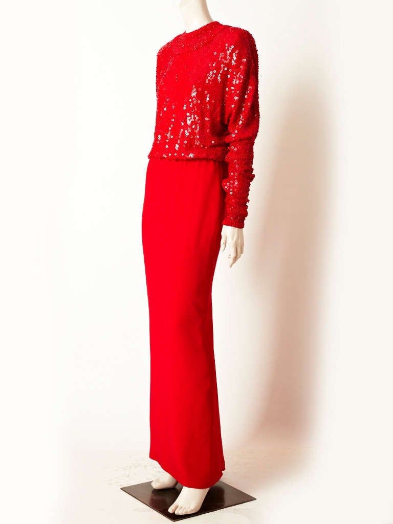 Galanos, Chinese red, 2 piece gown. Top is jeweled, neckline with long raglan sleeves that gather on the arm. Chiffon top is encrusted with red sequins and bugle beads. Long, silk crepe  skirt is straight with a back zipper.