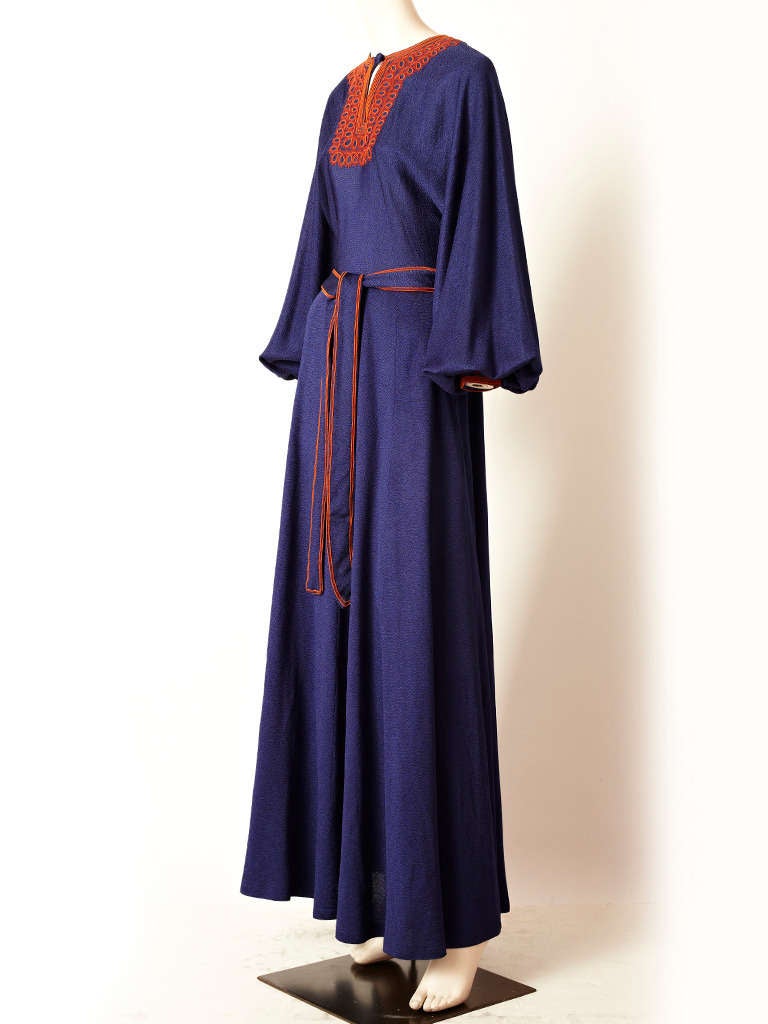 Jean Varon, Moroccan inspired, sapphire blue, crepe, jersey maxi dress with rust toned embroidery at the neckline and trim on the belt. Inspired from Moroccan caftans popular in the 