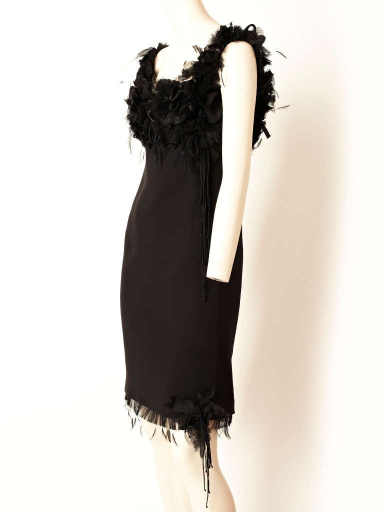 Chado Ralph Rucci, black, silk crepe, cocktail dress with a bodice embellished 
with a mix of ruched tulle, silk flowers, ribbons and feathers. Body of the dress is slightly fitted with a hem of frayed silk and feathers.