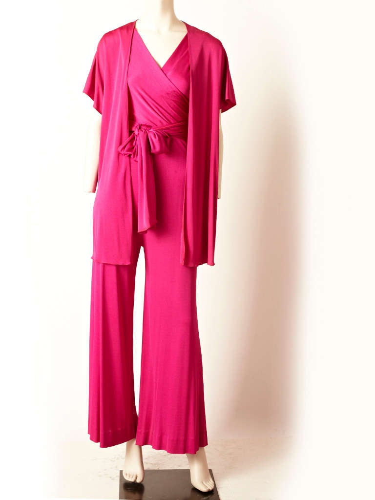 Scott Barrie, magenta, matte jersey jumpsuit with matching cardigan/jacket.
Sleeveless with wrap bodice and flared pant leg.