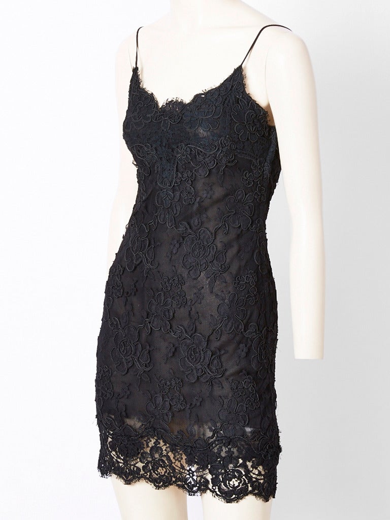 Calvin Klein, black,  embroidered  lace on tulle, cocktail dress. Dress has a slip like fitted body,with thin straps. It is lined in silk chiffon. The lining ends at the thigh and exposes some of the leg underneath. Simple and sexy dress.
