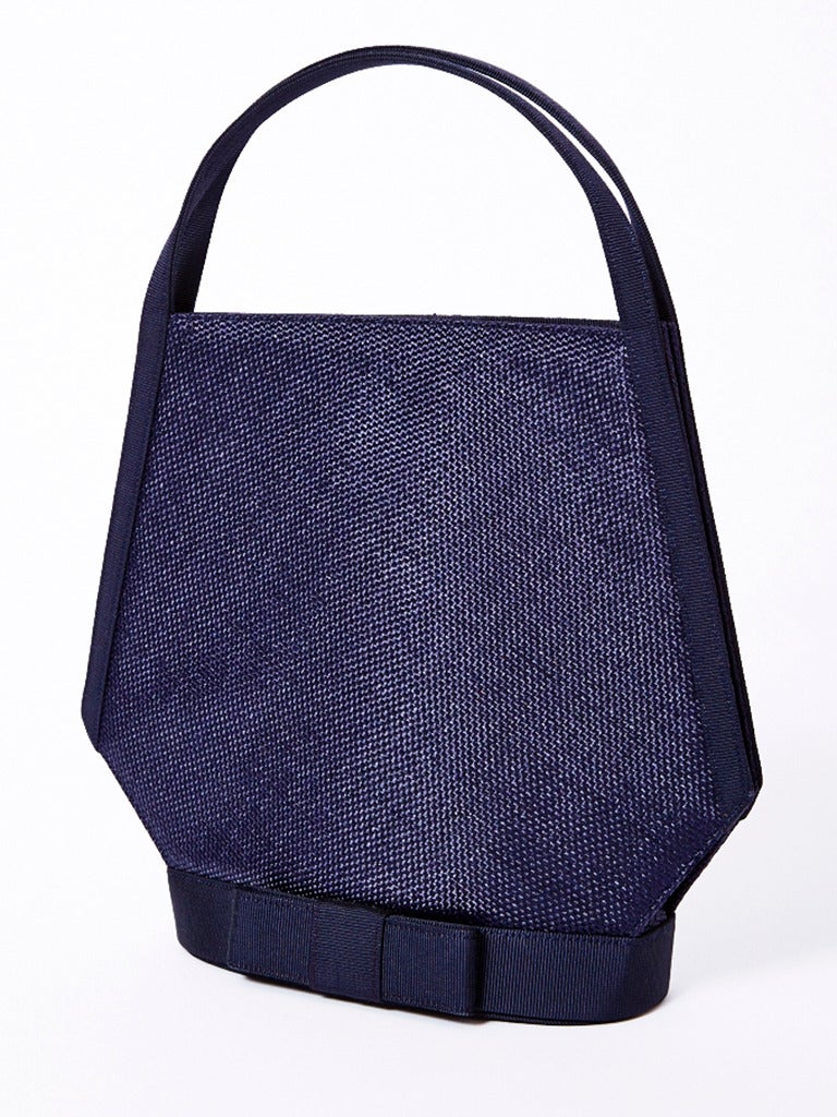 Guy Laroche, navy, raffia and gross grain ribbon, structured, summer evening handbag.
Body of the bag is a french raffia, edged in gross grain ribbon on the sides and base. There is a bow embellishment on the base of the bag in gross grain.
The