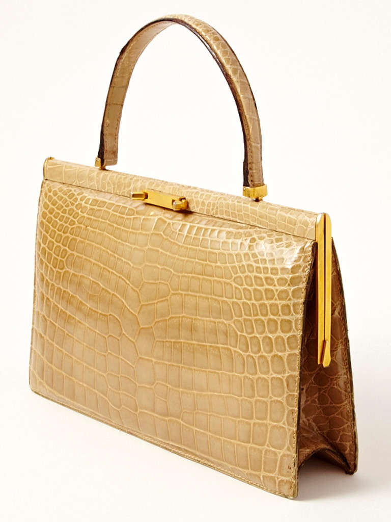 Taupe tone, crocodile hand bag with brass closure, made in France for Bloomingdales. Excellent restored condition.